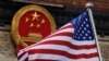 FILE - In this Nov. 9, 2017, file photo, an American flag is flown next to the Chinese national emblem during a welcome ceremony for visiting U.S. China says accusations against an alleged spy of attempting to steal trade secrets from several American aviation and aerospace companies were "made out of thin air." 
