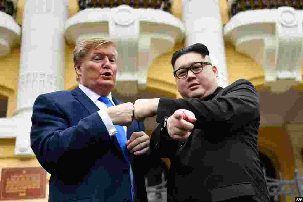 A President Donald Trump impersonator and a North Korean leader Kim Jong Un impersonator pose outside the Opera House in Hanoi.