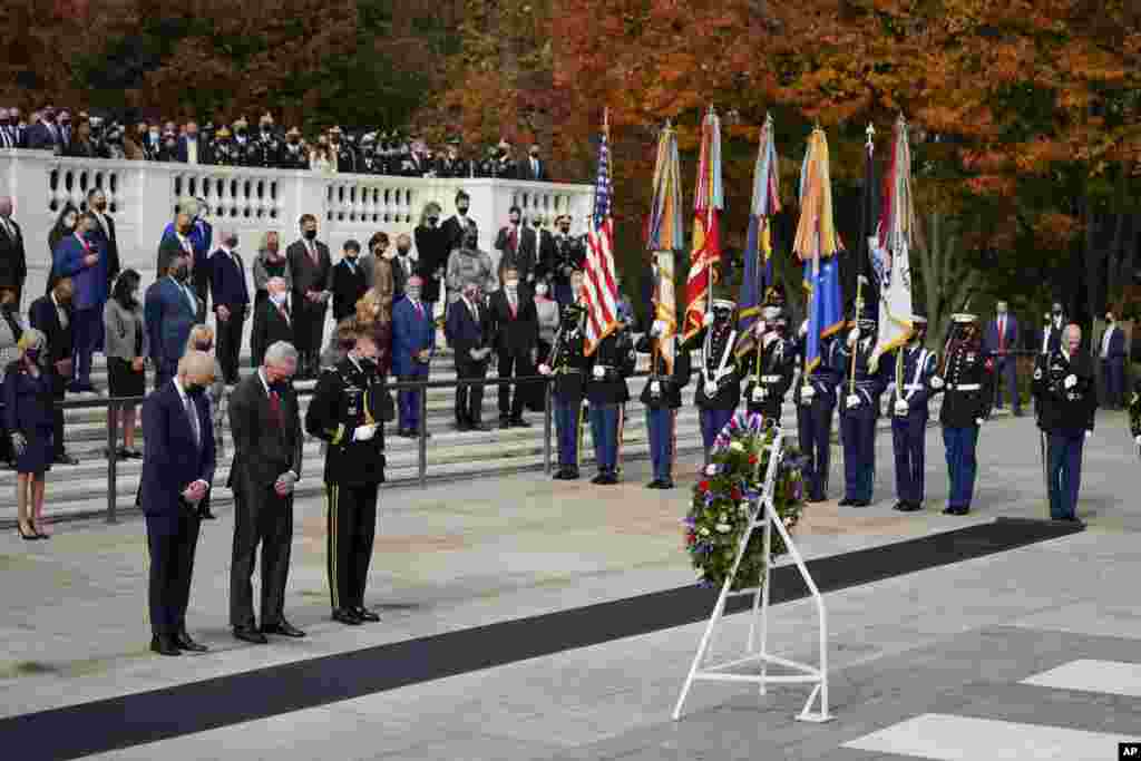 President Joe Biden stands with Veterans Affairs Secretary Denis McDonough and Army Maj. Gen. Allan M. Pepin during a wreath laying ceremony to commemorate Veterans Day and mark the centennial anniversary of the Tomb of the Unknown Soldier at Arlington National Cemetery in Arlington, Virginia.