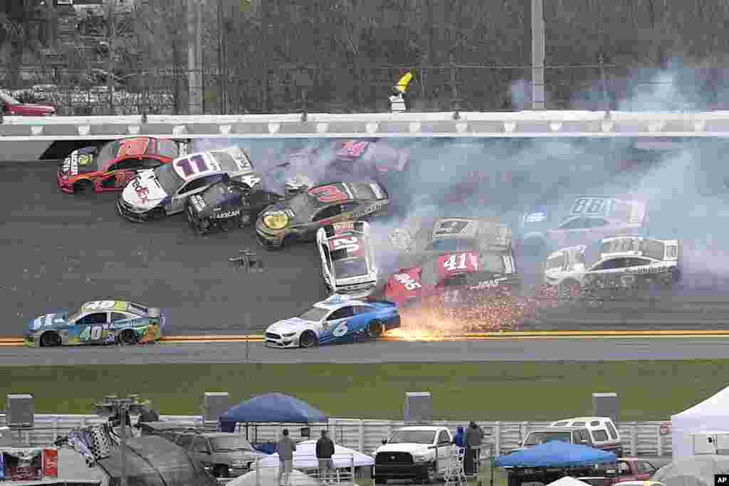 Martin Truex Jr. (19), Denny Hamlin (11), Kevin Harvick (4), Austin Dillon (3), Clint Bowyer (14), Erik Jones (20), Chase Elliott (9), Daniel Suarez (41), Ryan Newman (6), Alex Bowman (88) and Aric Almirola (10) are involved in a multi-car pileup during the NASCAR Clash auto race at Daytona International Speedway, Feb. 10, 2019, in Daytona Beach, Florida.
