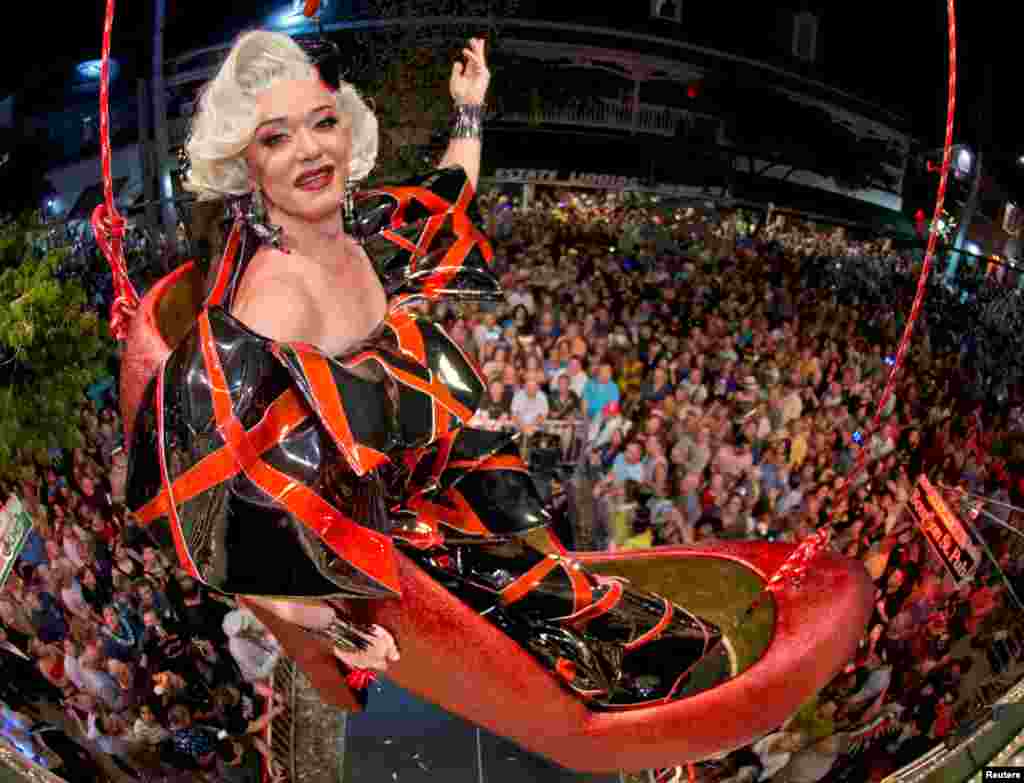 Gary Marion, also known as drag queen Sushi, hangs in an oversized replica of a women's red high heel during New Year's Eve celebrations on Duval Street at the Bourbon St. Pub in Key West, Florida, Dec. 31, 2018.