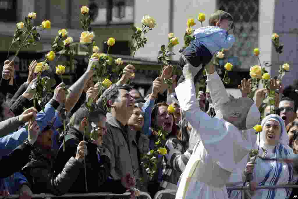 John Malkovich lifts a baby during the filming of 'The new Pope,' the sequel of Paolo Sorrentino's 'The young Pope,' in Rome, Italy, March 28, 2019.