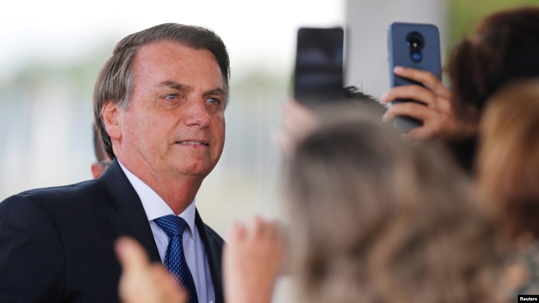 El presidente de Brasil posa para fotos de seguidores al salir del Palacio de la Alvorada en Brasilia, el 12 de diciembre de 2019. Foto REUTERS/Adriano Machado.