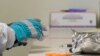 Pharmacist Michael Witte opens a frozen package of the potential vaccine for COVID-19 on the first day of a first-stage safety study clinical trial, at the Kaiser Permanente Washington Health Research Institute in Seattle. Washington, March 16, 2020. 