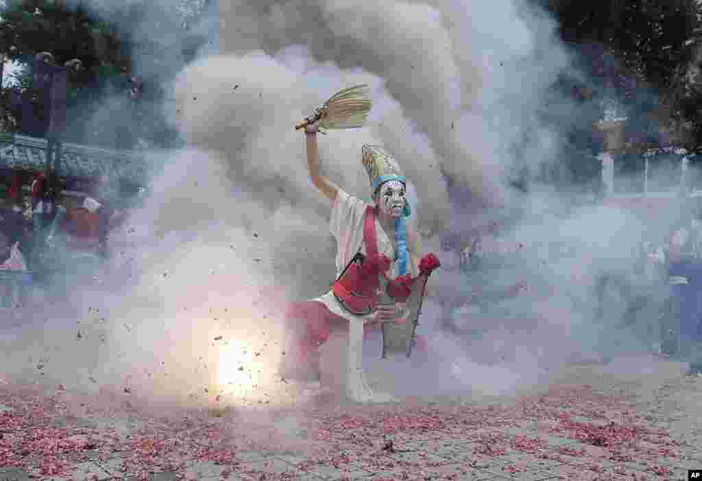 A participant dressed as Ba Jia Jiang, a Chinese guardian of the gods, is purified by firecrackers during a temple festival marking the birthday of traditional Taoist deity "Qingshan Wang" or "Ling''an Zunwang" in Taipei, Taiwan.