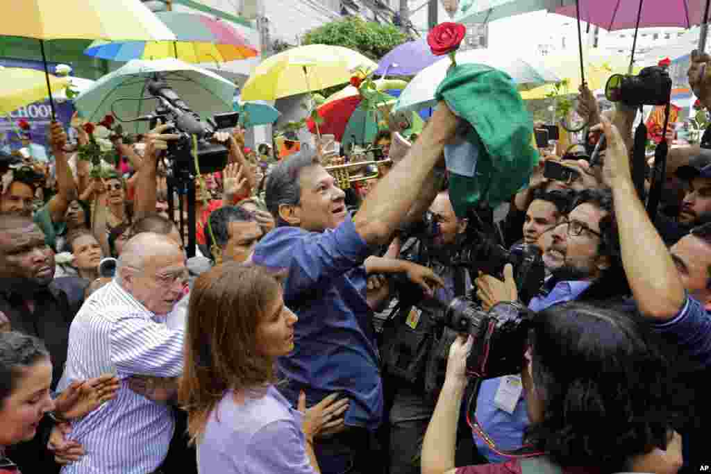 Workers' Party presidential candidate Fernando Haddad holds a Brazilian flag after casting his vote in the presidential election in Sao Paulo, Brazil.