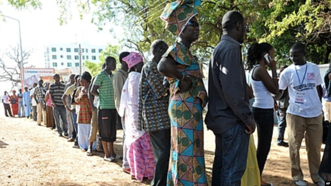 People wait to vote outside a polling station in Serrekunda, southwest the capital Banjul, during the presidential elections. Gambians voted in polls, which some observers said were skewed in favor of incumbent Yahya Jammeh, who heaped scorn on criticism