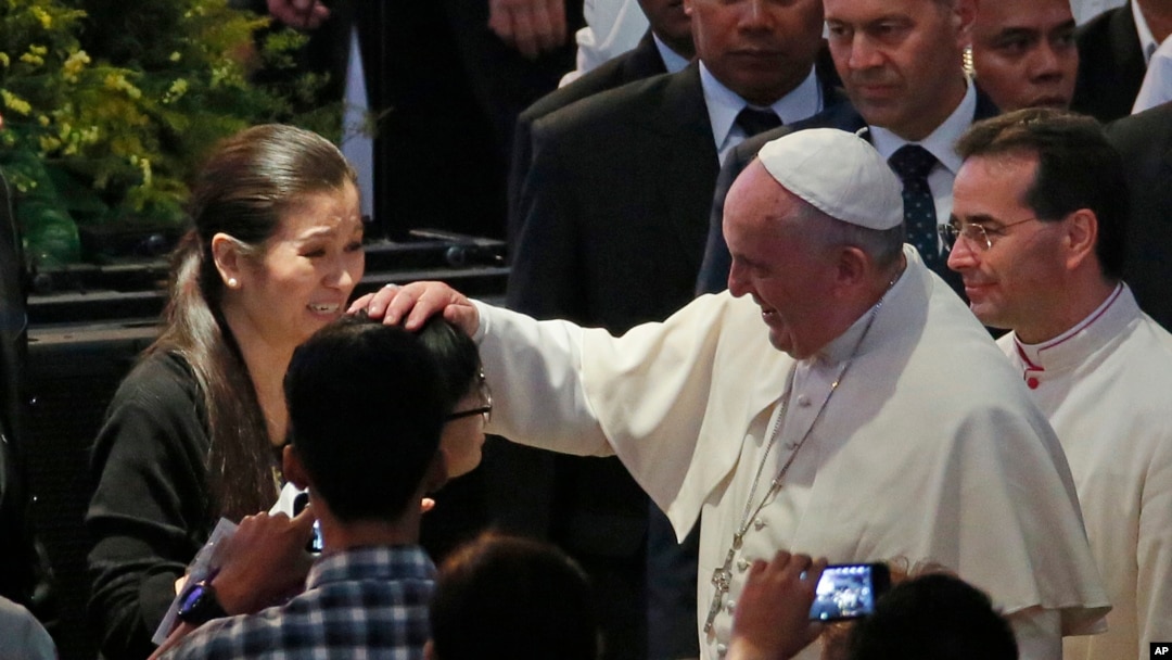 El Papa toca la cabeza de una niña a su llegada al Mall of Asia en Manila, este viernes, 16 de enero, de 2015.