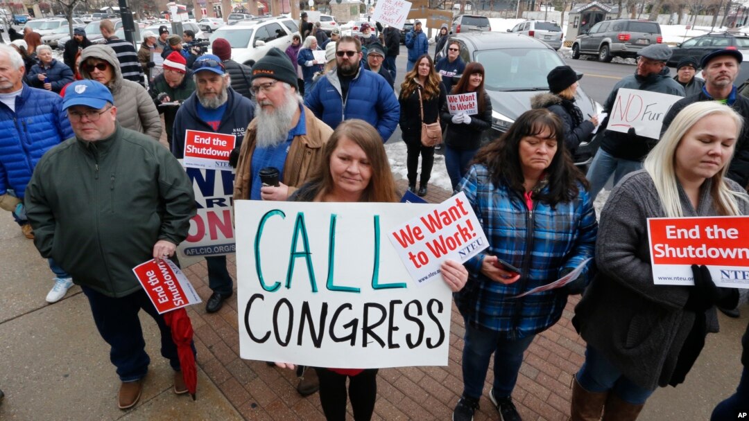 IRS worker Angela Gran, center, and others federal workers protest outside the Federal Building, Jan., 10, 2019, in Ogden, Utah. About 800,000 U.S. federal employees are affected by the government shutdown. (AP Photo/Rick Bowmer)