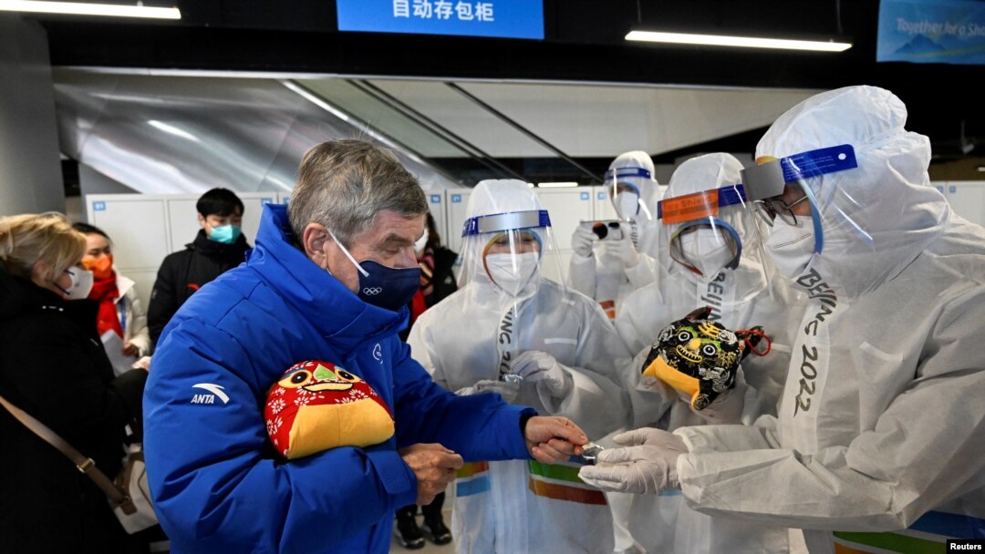 El presidente del Comité Olímpico Internacional, Thomas Bach, entrega regalos en el marco de los Juegos Olímpicos de Invierno de Beijing, el 1 de febrero de 2022.