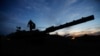 An Israeli soldier walks on an Israeli tank near the Israel-Gaza border, amid the temporary truce between Hamas and Israel, in southern Israel, Nov. 28, 2023. 