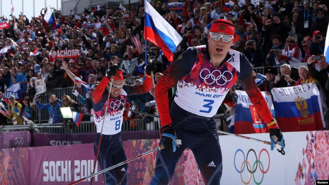Russia's Alexander Legkov and Ilia Chernousov (L) race to the finish line to take first and third place in the men's cross-country 50 km mass start free event at the Sochi 2014 Winter Olympic Games, Feb. 23, 2014.