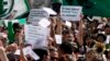 Ariel Heredia, quien se identifica como no binario, sostiene un cartel en defensa de cupo laboral para transgéneros en una protesta frente al Ministerio de Economía en Buenos Aires para exigir la reincorporación de trabajadores estatales despedidos, el 5 de abril de 2024. 