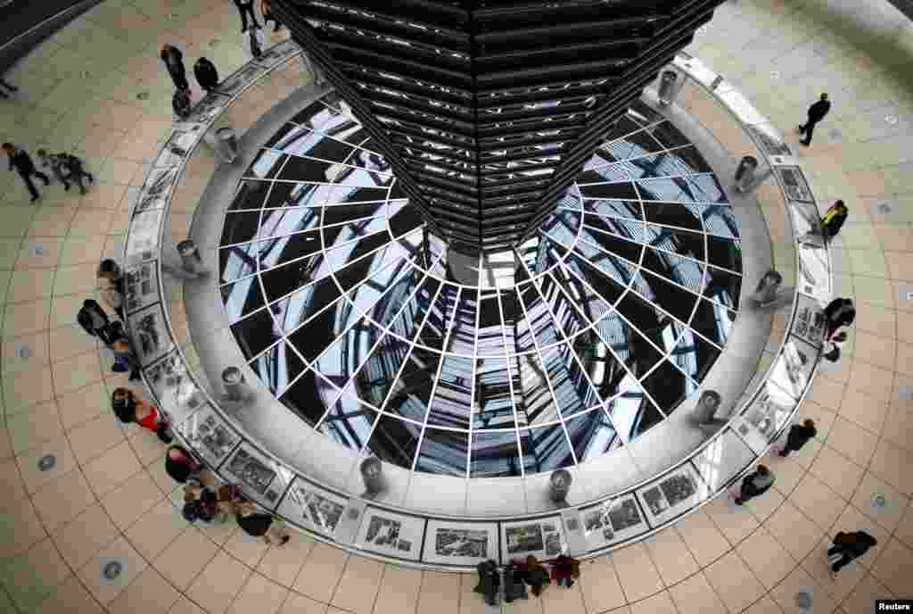 People walk inside the dome of the Reichstag building, the seat of the German lower house of parliament Bundestag in Berlin.