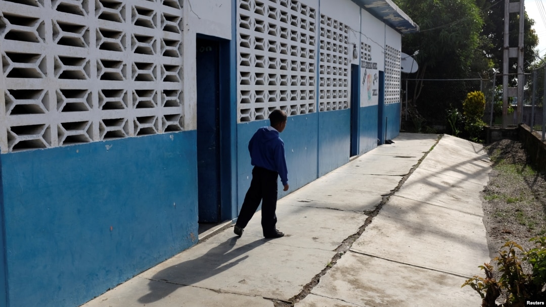 A kid walks past a classroom on the first day of school, in Caucagua, Venezuela, Sept. 17, 2018. 