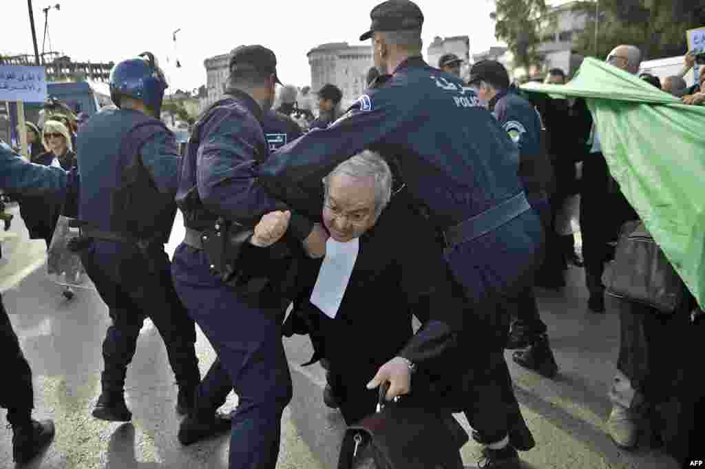Algerian police disperse a protest by lawyers and journalists against their ailing president's bid for a fifth term in power, in Algiers.