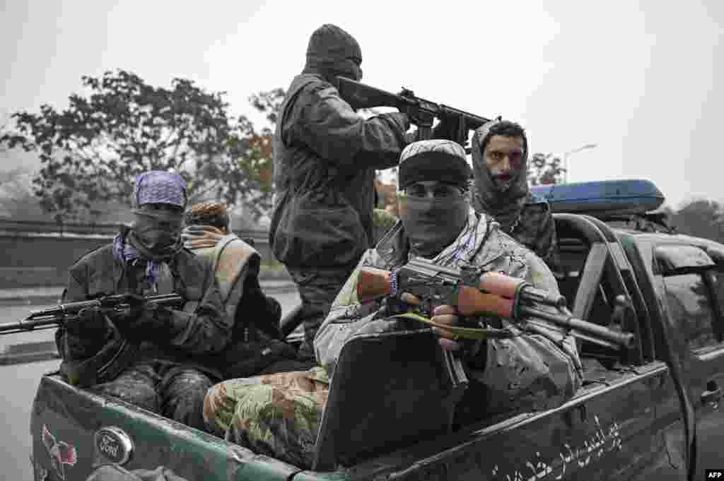 Taliban fighters patrol along a street during a demonstration by people to condemn the recent protest by the Afghan women's rights activists, in Kabul.