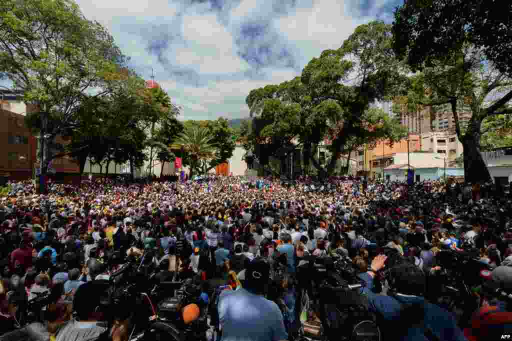Opposition supporters gather to listen to Venezuela's National Assembly head and the country's self-proclaimed 'acting president' Juan Guaido, at Bolivar Square in Chacao, eastern Caracas.