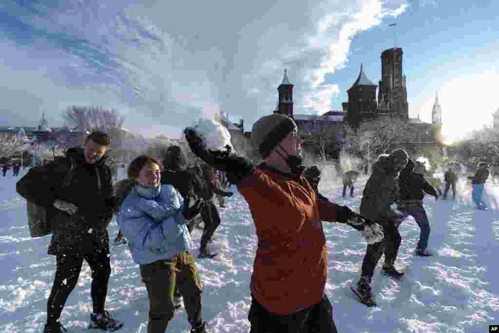 Snowballs fly during a snowball fight organized by the DC Snowball Fight Association, on the National Mall in the snow, Jan. 3, 2022, in Washington.