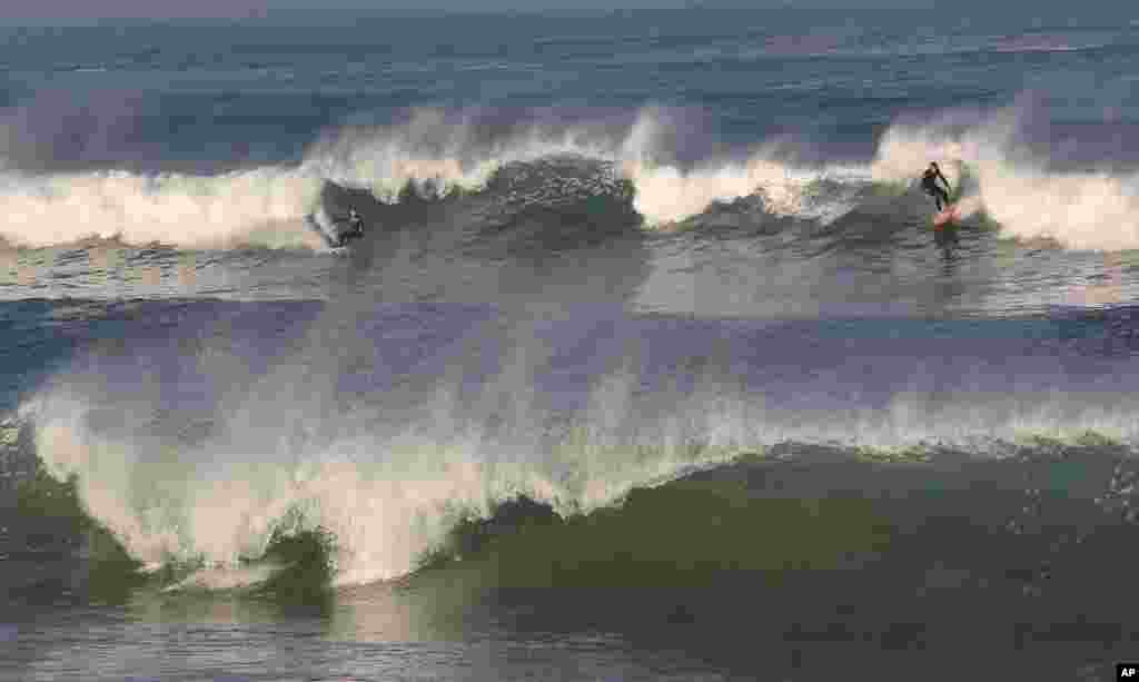 Surfers ride the waves in the Atlantic Ocean during unseasonably warm weather in Anglet, southwestern France.