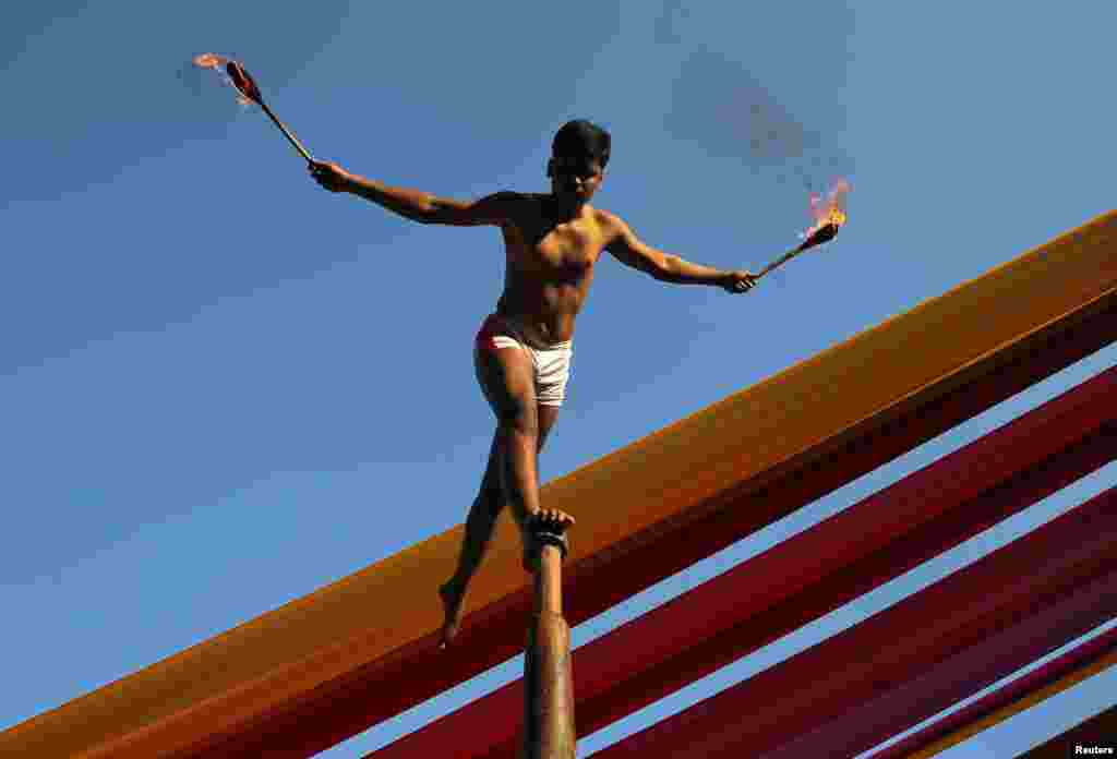 A man performs "Malkhamb" (traditional Indian gymnastics) during a college festival in Mumbai, India.