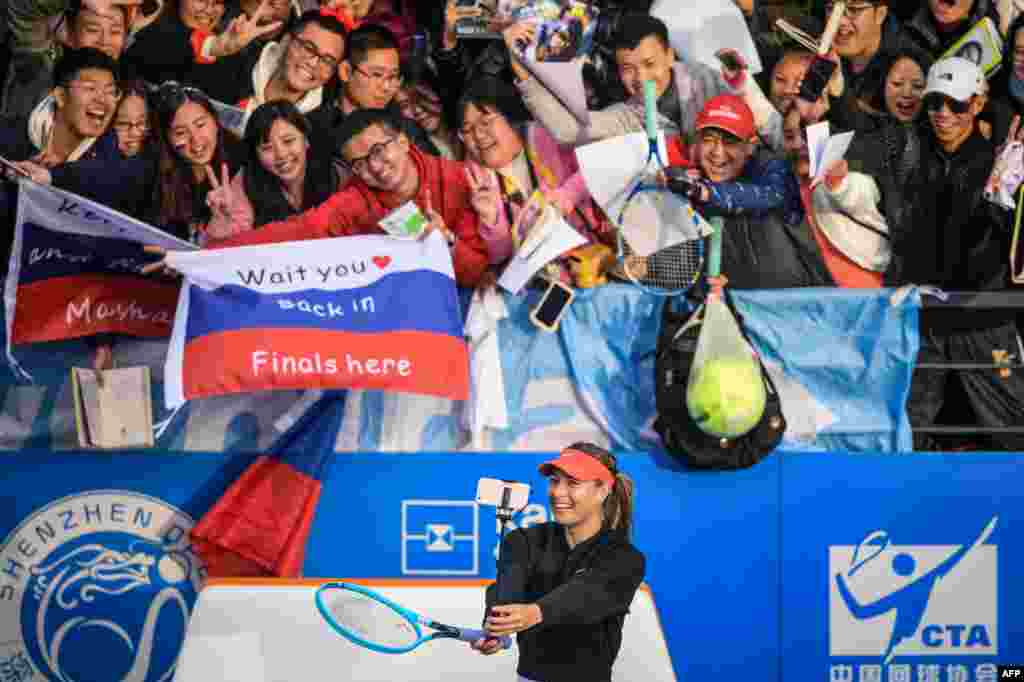Maria Sharapova (bottom) of Russia takes a selfie with fans after her women's singles first round match against Timea Bacsinszky of Switzerland at the Shenzhen Open tennis tournament in Shenzhen in China's southern Guangdong province.
