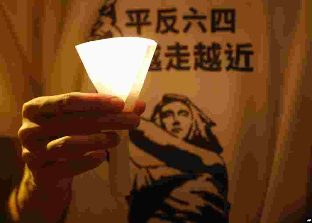 A man wears a T-shirt with Chinese reading "Vindicate June 4" at a candlelight vigil at Hong Kong's Victoria Park in Hong Kong Monday June 4, 2012 to mark the 23rd anniversary of the Chinese military crackdown on the pro-democracy movement in Beijing.