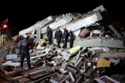 Rescue workers search on a collapsed building after an earthquake in Elazig, Turkey, January 25, 2020.