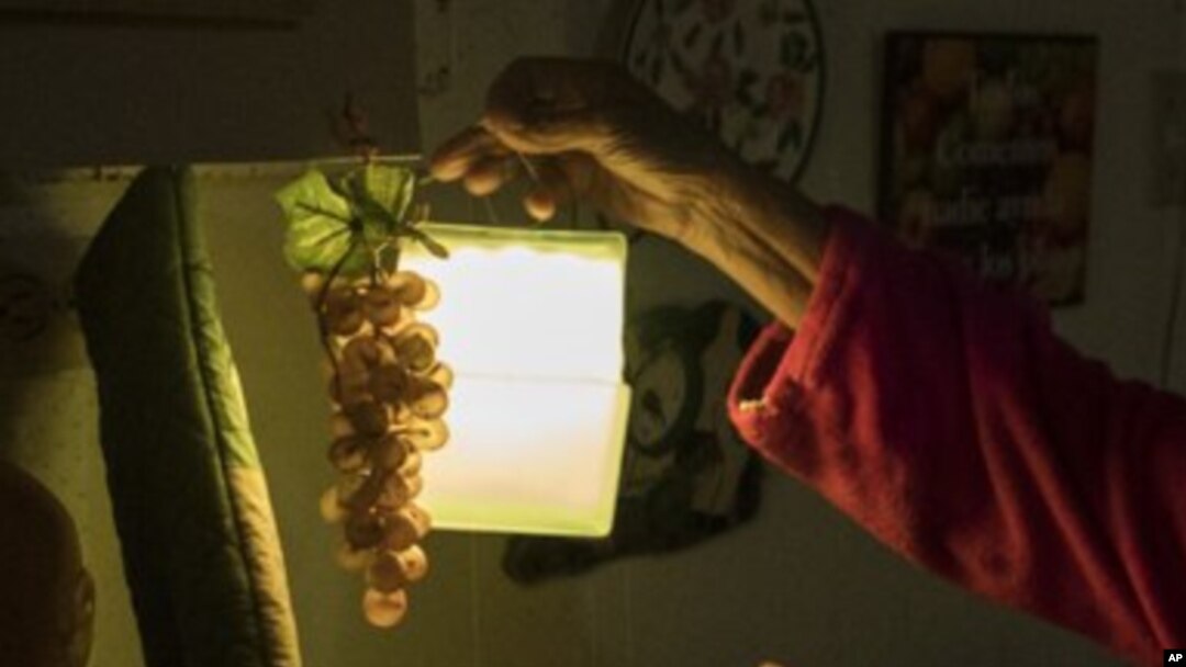 ARCHIVO - Las compañías productoras de energía hidroelétrica anunciaron este martes en Ecuador que inician racionamientos ante la sequía que castiga al país. Esta imagen ilustrativa mustra una lampara de mano sostenida por una mujer durante apagón en Puerto Rico en julio de 2018.