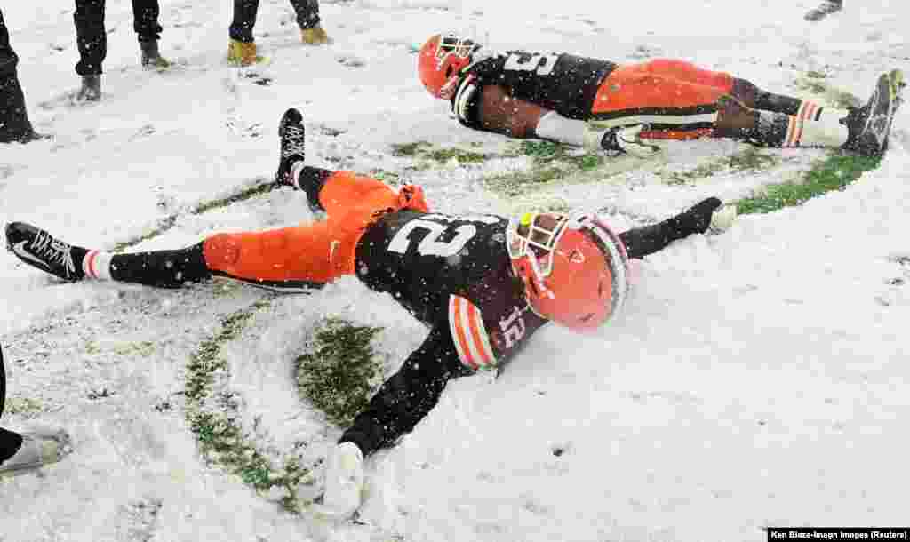 Cleveland Browns safety Rodney McLeod Jr. (12) and defensive end Ogbo Okoronkwo (54) celebrate in the snow after the Browns beat the Pittsburgh Steelers at Huntington Bank Field in Cleveland, Ohio, Nov. 21, 2024.
