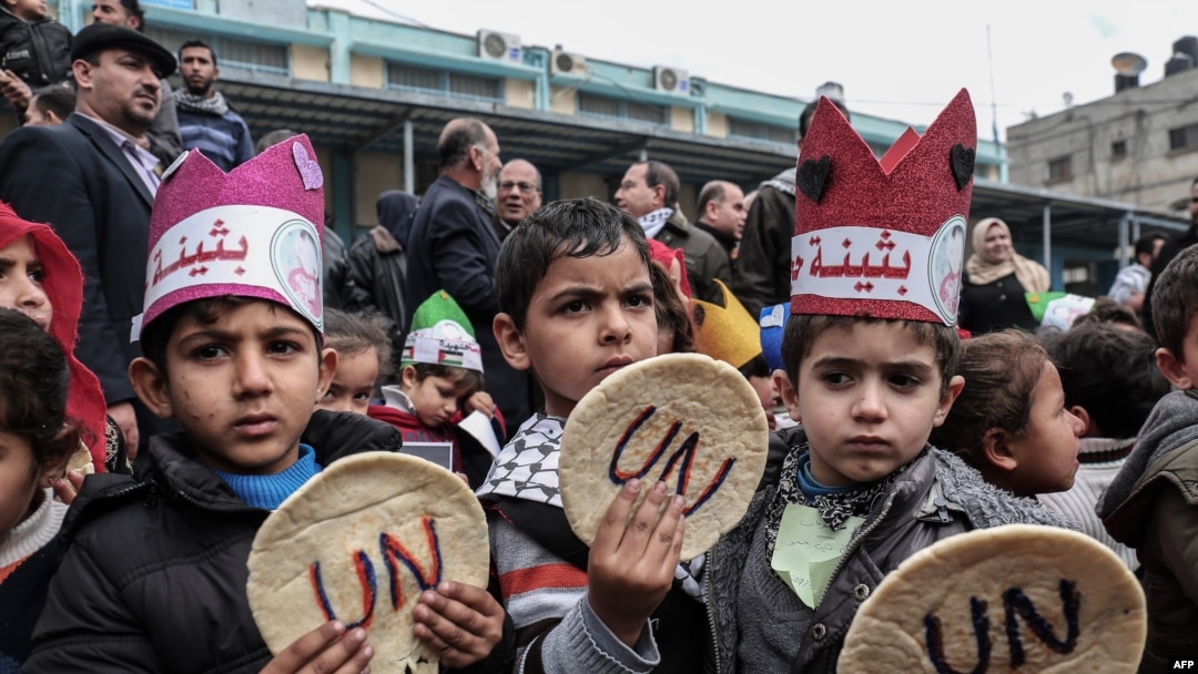 FILE - Palestinian children hold bread patties during a protest against aid cuts, outside the United Nations' offices in Khan Yunis in the southern Gaza Strip on Jan. 28, 2018.