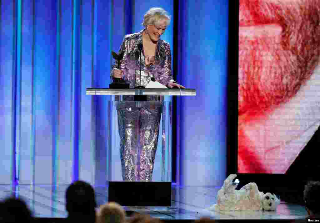 American actress Glenn Close accepts her award for Best Female Lead for the film "The Wife" as her dog Pip rolls around on the stage in Santa Monica, California, Feb. 23, 2019.