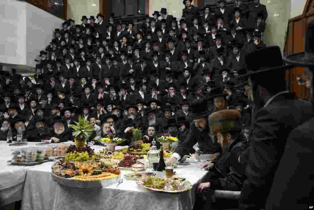 Ultra-Orthodox Jews of the Sadigura Hasidic dynasty celebrate the Jewish feast of 'Tu Bishvat' or "New Year of the Trees." as they sit with their rabbis around a long table filled with fruits, in the ultra-Orthodox town of Bnei Brak, Israel, Jan. 16, 2022.