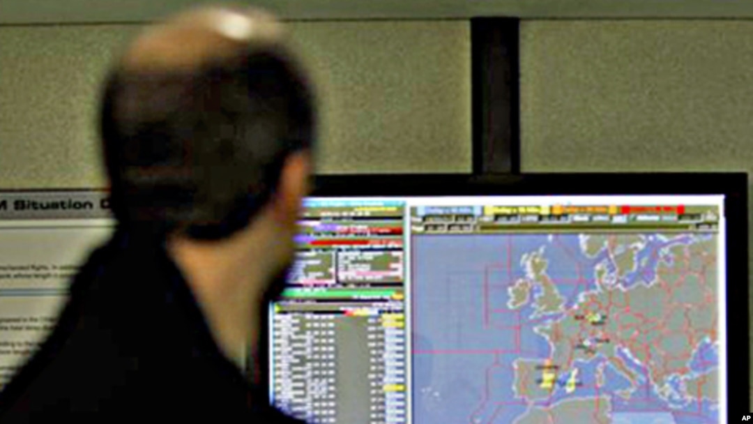 A man walks by a display screen which shows the Libyan 'No-Fly' zone, highlighted in blue at bottom right, at Eurocontrol in Brussels, March 18, 2011