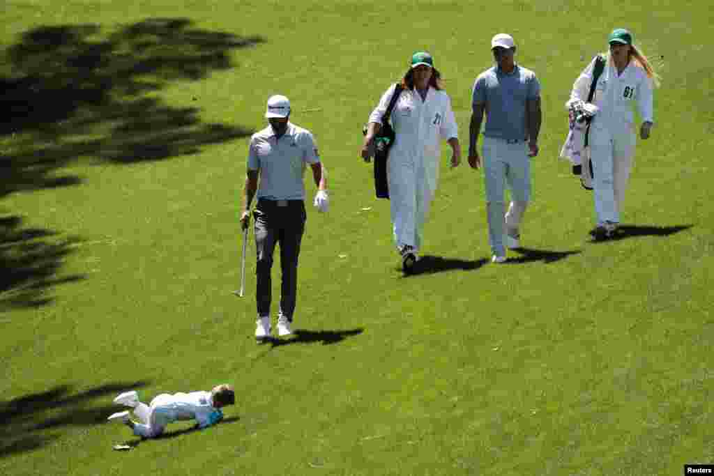 Dustin Johnson's son Tatum rolls down the hill as he joins his father during the 2019 Masters golf tournament's par 3 contest at the Augusta National Golf Club in Augusta, Georgia, April 10, 2019.