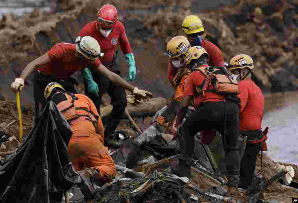 Firefighters pull a body from the mud days after a dam collapse in Brumadinho, Brazil. Firefighters carefully moved over treacherous mud, sometimes walking, sometimes crawling, in search of survivors or bodies four days after a dam collapse that buried mine buildings and surrounding neighborhoods with iron ore waste.