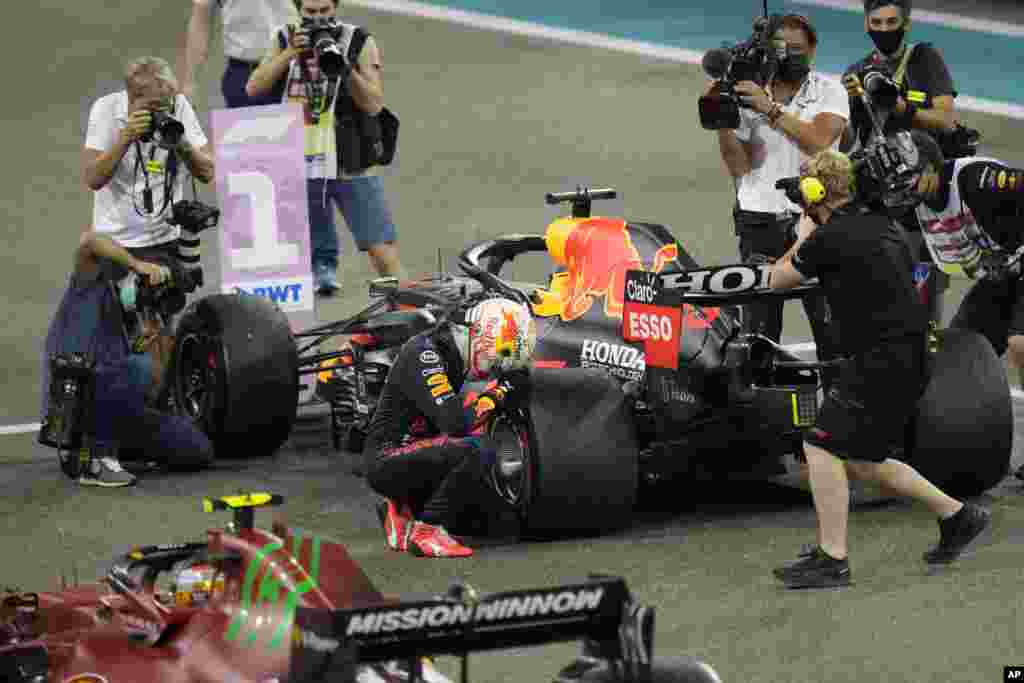 Red Bull driver Max Verstappen of the Netherlands kneels next to his car after winning the Formula One Abu Dhabi Grand Prix and after he became the world champion, in Abu Dhabi, United Arab Emirates.