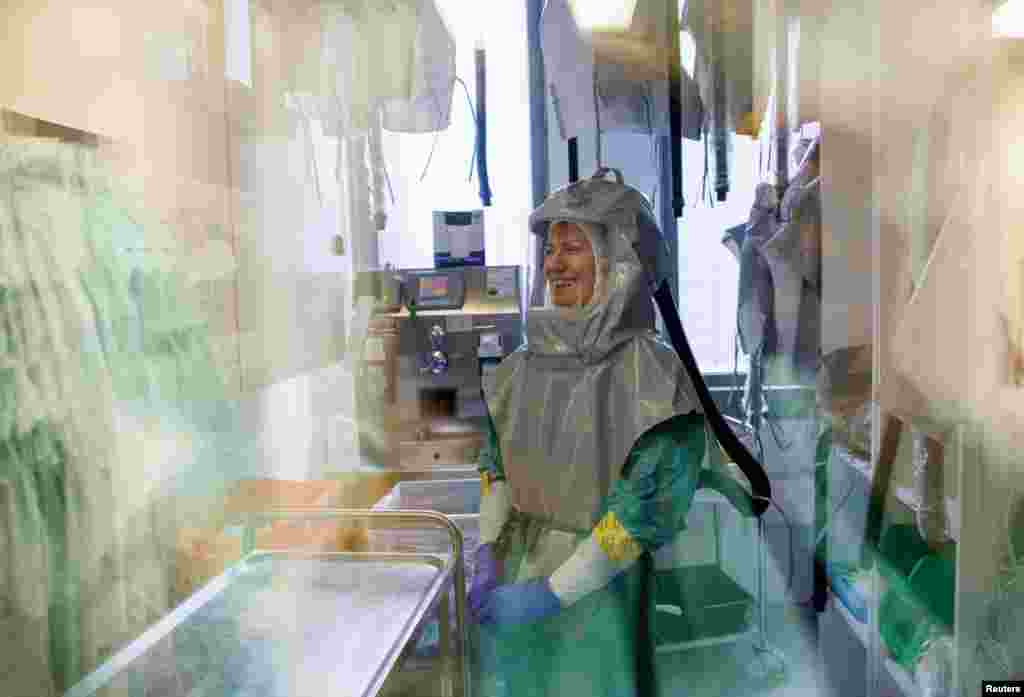 A biologist at the French-Austrian biotech firm Valneva waits in a double door system before entering a laboratory to work on an inactivated whole-virus vaccine against COVID-19 in Vienna, Austria.