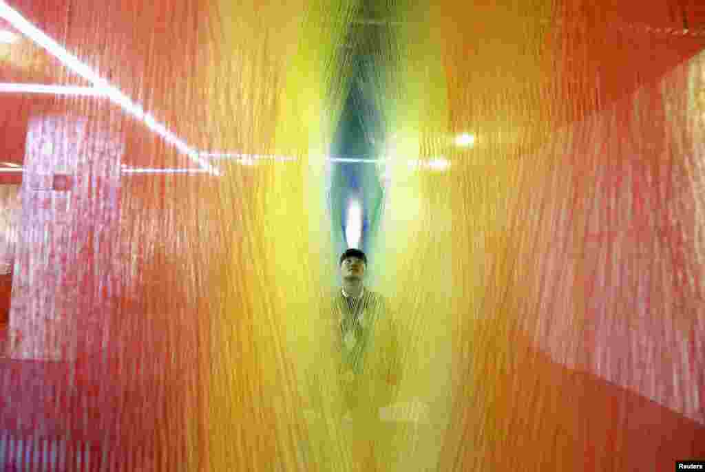 A man looks at an installation made of sock textiles on display at a demonstration hall of the local sock-making industry in Zhuji, Zhejiang province, China, Feb. 2, 2015. 