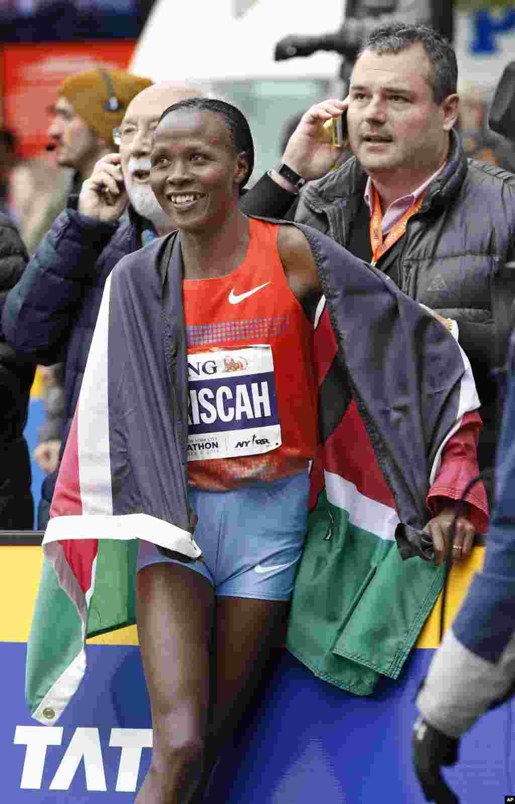 Women's winner Priscah Jeptoo of Kenya reacts with members of her team after coming in first in the women's division of the New York City Marathon, Nov. 3, 2013, in New York.