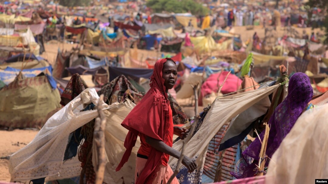A Sudanese girl who fled the conflict in Sudan's Darfur region, and was previously internally displaced in Sudan, moves past makeshift shelters, near the border between Sudan and Chad, while taking refuge in Borota, Chad, May 13, 2023. 