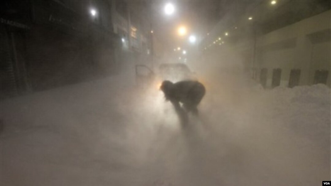 En Nueva Jersey, Karina Chernes trata de limpiar la nieve alrededor de su auto para poder circular, mientras la nevisca continúa.