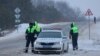Oficiales de la policía de tránsito hacen guardia en una carretera cerca del lugar del accidente del avión de transporte militar ruso Ilyushin Il-76 en las afueras de la aldea de Yablonovo en la región de Belgorod, Rusia, el 24 de enero de 2024. 