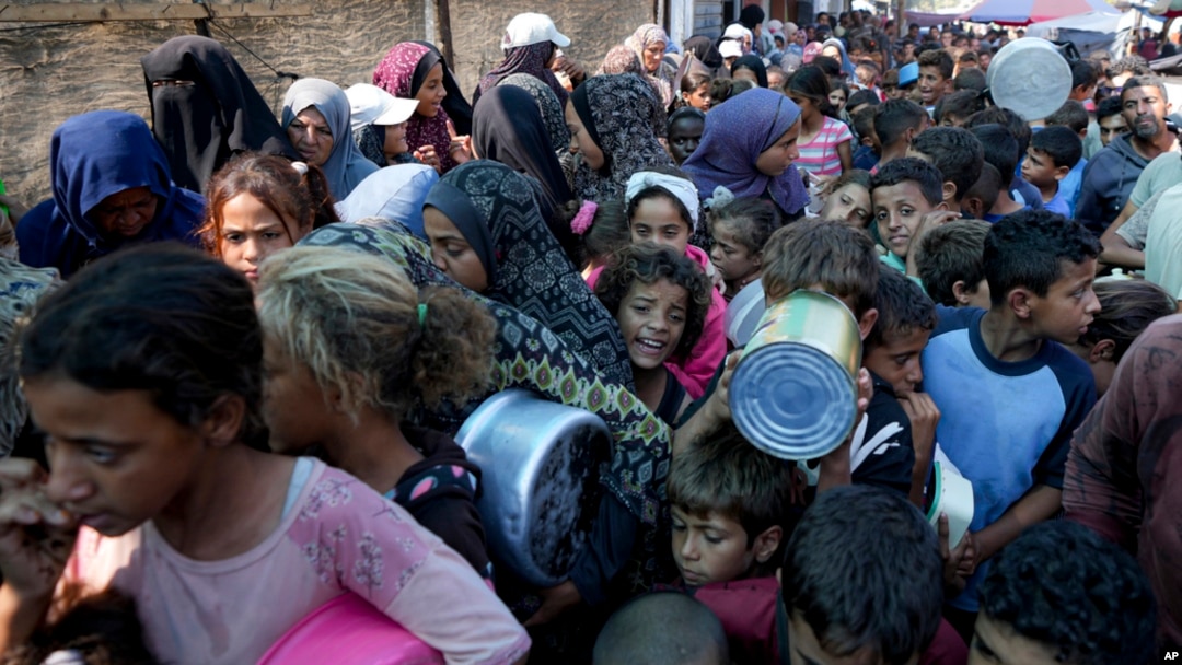 FILE - Palestinians line up for food distribution in Deir al-Balah, Gaza Strip, on Oct. 17, 2024.