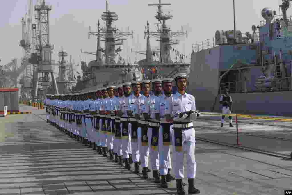 Pakistani Naval personnel march as they carry the flags of the countries participating in the navy's Multinational Exercise 'AMAN-19' in Karachi.