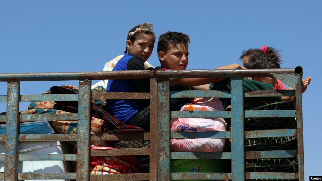 Children ride on a truck with belongings in Deraa countryside, Syria, June 22, 2018.