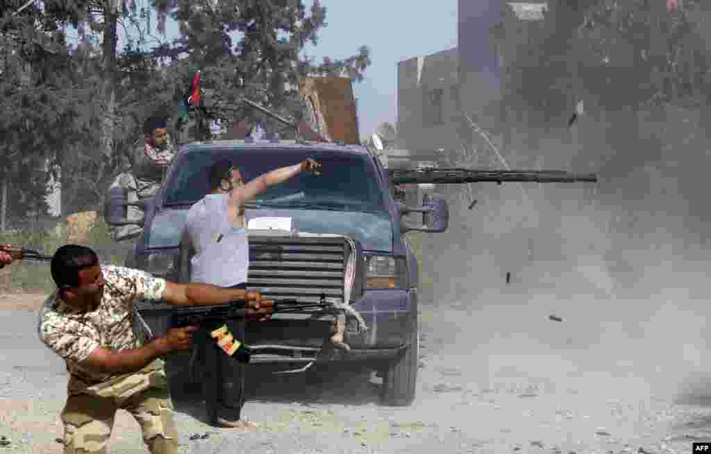 Libyan fighters loyal to the Government of National Accord (GNA) fire their guns during clashes with forces loyal to strongman Khalifa Haftar south of the capital Tripoli's suburb of Ain Zara, April 20, 2019.