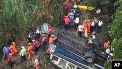 Firefighters work the scene of a fatal bus crash after it fell from a bridge on the outskirts of Guatemala City, Guatemala, Feb. 10, 2025.