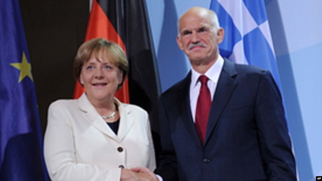 German Chancellor Angela Merkel and the Prime Minister of Greece, Georgios Papandreou shake hands prior to a dinner at the chancellery in Berlin, Germany, Sept. 27, 2011.