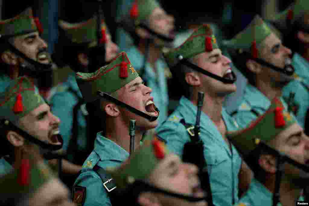 Spanish legionnaires sing in the rain outside a church during a ceremony ahead of the Mena brotherhood procession during Holy Week, in Malaga, Spain.